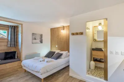 a bedroom with a bed and a mirror at Studio Loup - L'Igloo - Welkeys in Combloux