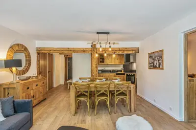 a kitchen and living room with a dining room table at Appartement Vue Montagnarde - Welkeys in Combloux