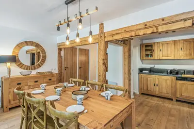 a kitchen and dining room with a wooden table and chairs at Appartement Vue Montagnarde - Welkeys in Combloux