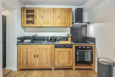 a kitchen with wooden cabinets and a stove at Appartement Vue Montagnarde - Welkeys in Combloux