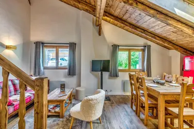 a dining room with a table and chairs and a bed at Appartement Alpage - Welkeys in Combloux