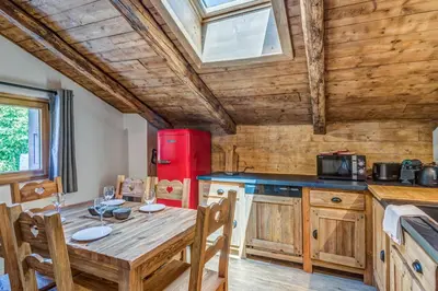 a kitchen with a table and a red refrigerator at Appartement Alpage - Welkeys in Combloux