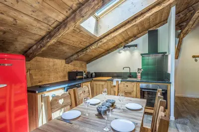a kitchen with a wooden table and a red refrigerator at Appartement Alpage - Welkeys in Combloux