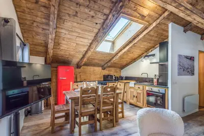 a kitchen with wooden ceilings and a table and chairs at Appartement Alpage - Welkeys in Combloux