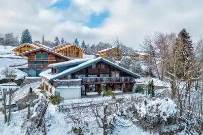 a log home in the snow with snow covered trees at Appartement La Combe aux Loups - Welkeys in Combloux