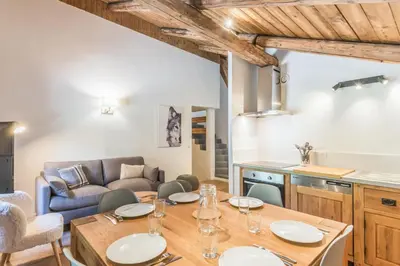 a kitchen and living room with a table and a couch at Appartement La Combe aux Loups - Welkeys in Combloux