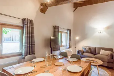 a living room with a table and a couch at Appartement La Combe aux Loups - Welkeys in Combloux