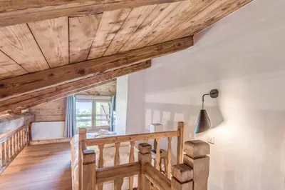 a staircase in a house with wooden ceilings at Appartement La Pause de l'Ours - Welkeys in Combloux