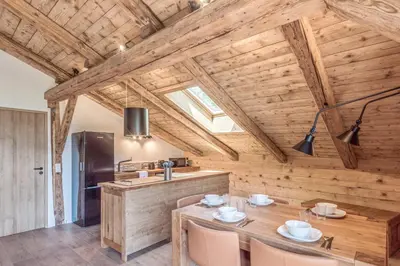 a kitchen with a wooden ceiling with a table and chairs at Appartement La Pause de l'Ours - Welkeys in Combloux