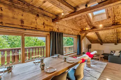 a dining room with a large wooden table and chairs at Appartement Le Mont-Blanc - Welkeys in Combloux
