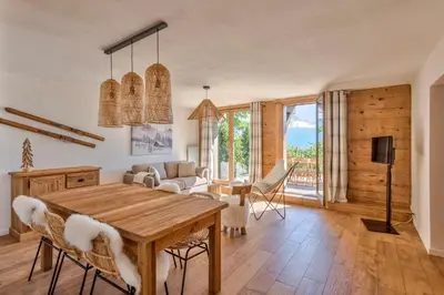 a living room with a wooden table and chairs at Appartement Snow - Welkeys in Combloux