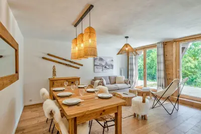a living room with a wooden table and chairs at Appartement Snow - Welkeys in Combloux