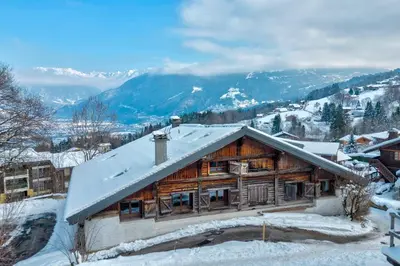 a log cabin with snow on the roof at Appartement Snow - Welkeys in Combloux