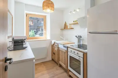 a kitchen with white appliances and a window at Appartement Snow - Welkeys in Combloux