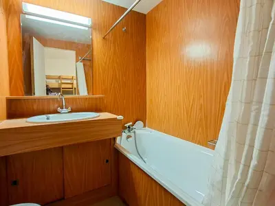 a bathroom with a sink and a tub and a mirror at Studio lumineux avec balcon et casier à ski proche des pistes - FR-1-425-185 in Arâches-la-Frasse
