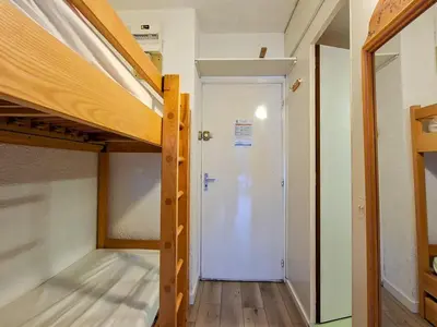 a room with a loft bed and a door to a closet at Studio lumineux avec balcon et casier à ski proche des pistes - FR-1-425-185 in Arâches-la-Frasse