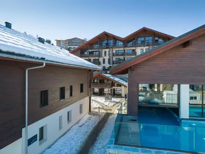 a view of a building from between two buildings at Les Roches du Mont Blanc - Résidence & Spa in Combloux