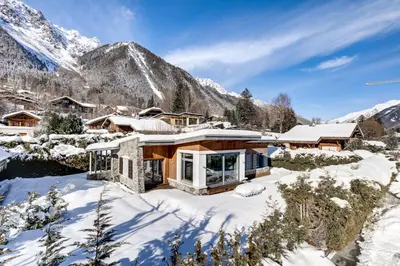 a house in the snow with mountains in the background at Chalet Safari. Face au Mont-Blanc. in Chamonix-Mont-Blanc