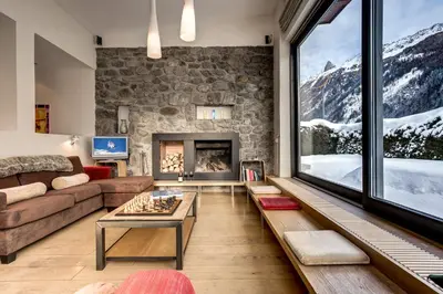 a living room with a couch and a fireplace at Chalet Safari. Face au Mont-Blanc. in Chamonix-Mont-Blanc