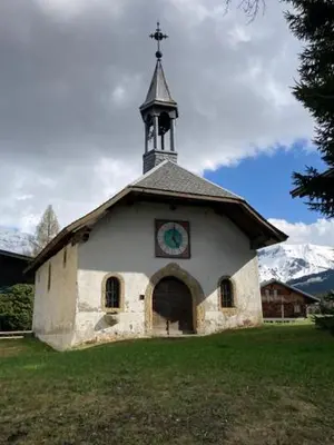 a church with a steeple with a clock on it at LE 1307 in Megève