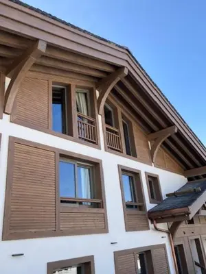 a building with windows and wooden shutters on it at LE 1307 in Megève