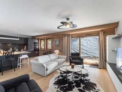 a living room with a couch and a table at Appartement de Standing à Megève, 5 Min des Pistes, Sauna, Hammam, Parking, Animaux Acceptés - FR-1-569-52 in Megève
