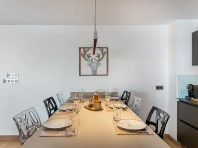 a dining room with a table with chairs and a table at Appartement de Standing à Megève, 5 Min des Pistes, Sauna, Hammam, Parking, Animaux Acceptés - FR-1-569-52 in Megève