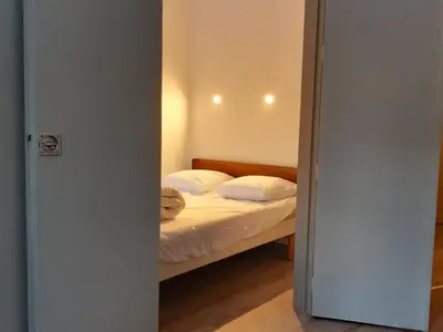 a bedroom with a bed with white sheets and pillows at Appartement Chamonix - 2 Pièces, Casier à ski, Près des bus - FR-1-517-62 in Chamonix-Mont-Blanc