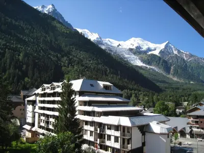 a building in front of a mountain with snow at Appartement Chamonix - 2 Pièces, Casier à ski, Près des bus - FR-1-517-62 in Chamonix-Mont-Blanc