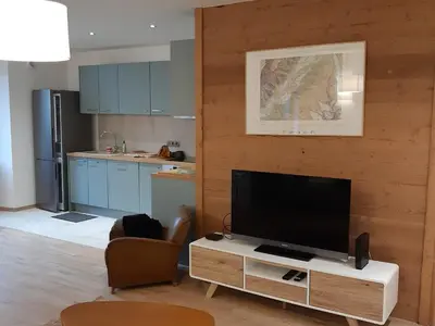 a living room with a flat screen tv on a wooden wall at Appartement rénové avec jardin, proche activités et centre, piscine et randonnées à 5mn - FR-1-517-60 in Chamonix-Mont-Blanc