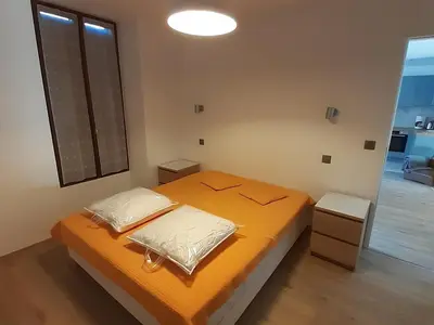 a bedroom with an orange bed and a window at Appartement rénové avec jardin, proche activités et centre, piscine et randonnées à 5mn - FR-1-517-60 in Chamonix-Mont-Blanc
