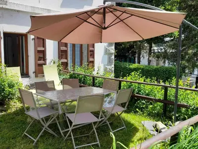 a table and chairs with an umbrella in the yard at Appartement rénové avec jardin, proche activités et centre, piscine et randonnées à 5mn - FR-1-517-60 in Chamonix-Mont-Blanc