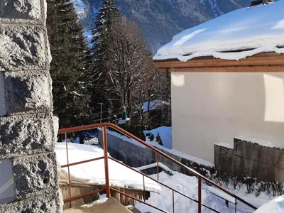 a snow covered staircase to a building with a snow covered roof at Appartement rénové avec jardin, proche activités et centre, piscine et randonnées à 5mn - FR-1-517-60 in Chamonix-Mont-Blanc