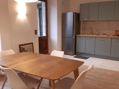 a kitchen with a wooden table and a refrigerator at Appartement rénové avec jardin, proche activités et centre, piscine et randonnées à 5mn - FR-1-517-60 in Chamonix-Mont-Blanc