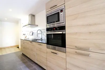 a kitchen with a stove and a microwave at Cozy Alpine Stay Séjour cosy au centre in Chamonix-Mont-Blanc