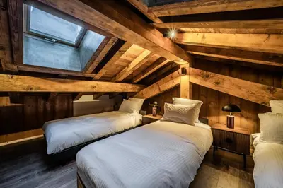 two beds in a room with wooden walls at Chalet Olea Chamonix - by EMERALD STAY in Chamonix-Mont-Blanc