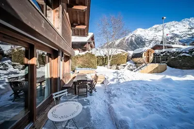 a patio with tables and chairs in the snow at Chalet Olea Chamonix - by EMERALD STAY in Chamonix-Mont-Blanc