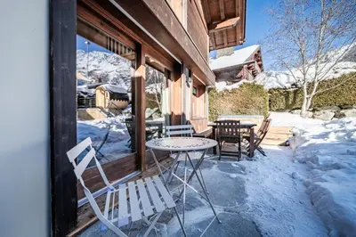 a patio with a table and chairs in the snow at Chalet Olea Chamonix - by EMERALD STAY in Chamonix-Mont-Blanc
