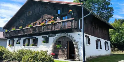 a building with a balcony with flowers on it at A Cordon entre Bois et Nature in Cordon