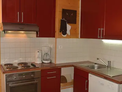 a small kitchen with red cabinets and a sink at Duplex Confortable 3P - 6/8 Pers - Balcon - FR-1-425-127 in Arâches-la-Frasse