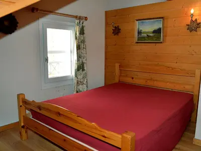 a bedroom with a red bed in a room with a window at Duplex Confortable 3P - 6/8 Pers - Balcon - FR-1-425-127 in Arâches-la-Frasse