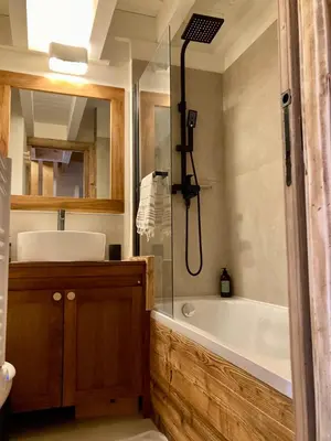 a bathroom with a bath tub and a sink at Appartement ensoleillé aux Tines, vue Massif in Chamonix-Mont-Blanc