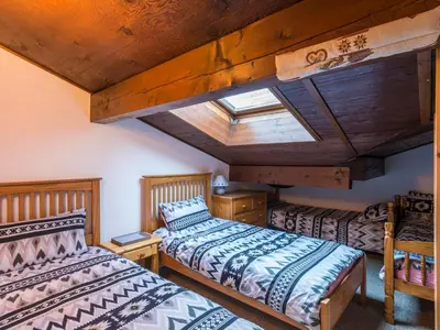 two beds in a room with a wooden ceiling at Ski-in/ski-out & pool: great for summer and winter in Saint-Gervais-les-Bains