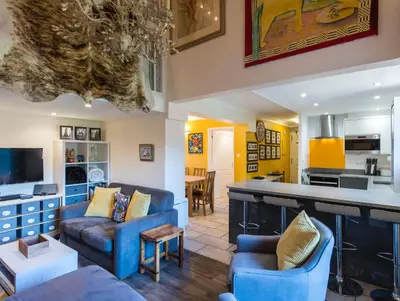 a living room with blue furniture and a kitchen at Ski-in/ski-out & pool: great for summer and winter in Saint-Gervais-les-Bains