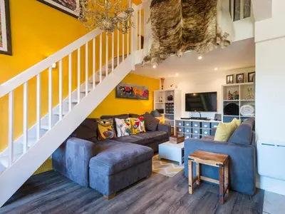 a living room with yellow walls and a staircase at Ski-in/ski-out & pool: great for summer and winter in Saint-Gervais-les-Bains