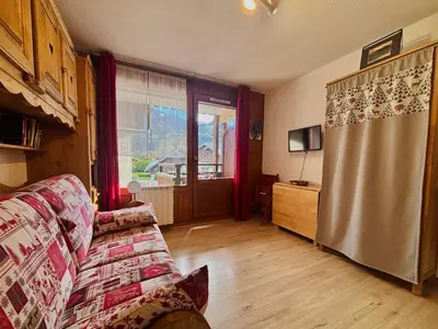 a living room with a couch and a window at Studio cosy centre village, animaux acceptés, parking privé - FR-1-624-121 in Samoëns