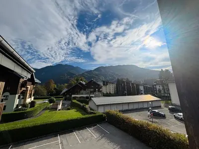 a view of a parking lot with mountains in the background at Studio cosy centre village, animaux acceptés, parking privé - FR-1-624-121 in Samoëns