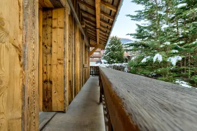 a building with a wooden fence next to a sidewalk at Chalet Chèvrefeuille in Saint-Gervais-les-Bains