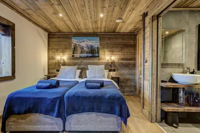 a bedroom with two beds and a bathroom with a sink at Chalet Chèvrefeuille in Saint-Gervais-les-Bains