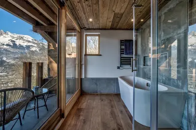 a bathroom with a tub and glass walls at Chalet Chèvrefeuille in Saint-Gervais-les-Bains
